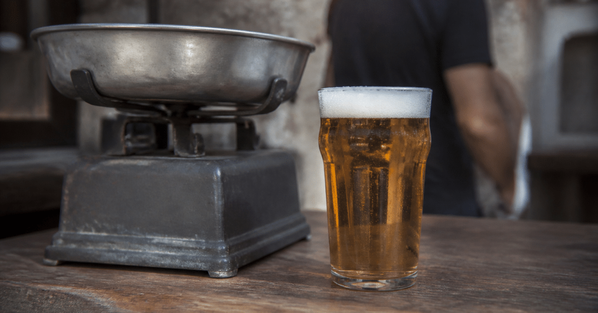 Verre de biere plein pose pres d'une balance pese