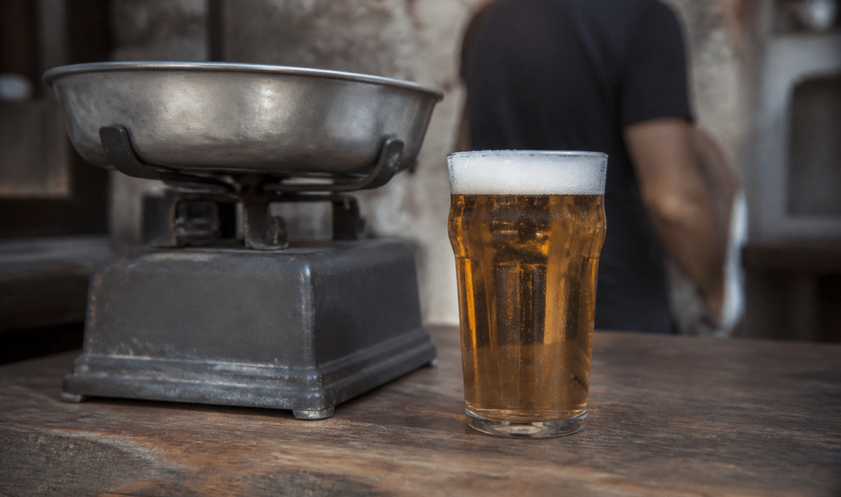 Verre de biere plein pose pres d'une balance pese