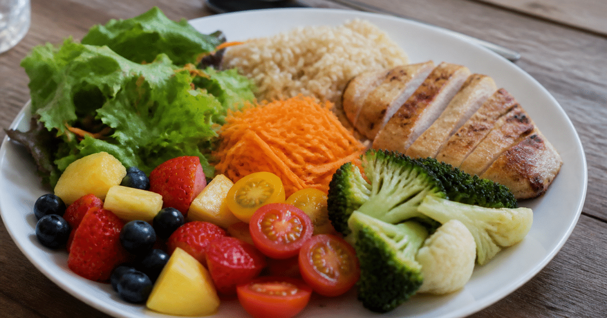 Assiette equilibree presentant fruits, legumes, proteines et cereales completes