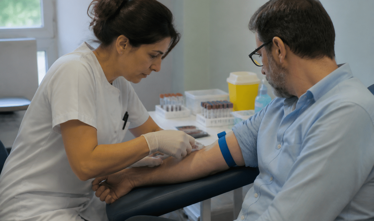 Infirmiere prelevant le sang d'un patient assis