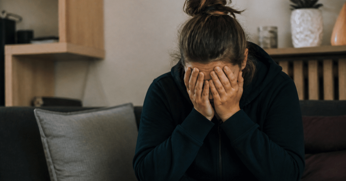 Personne assise tenant sa tete entre ses mains