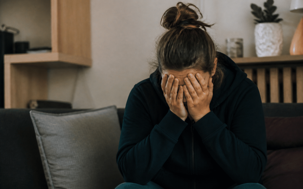 Personne assise tenant sa tete entre ses mains