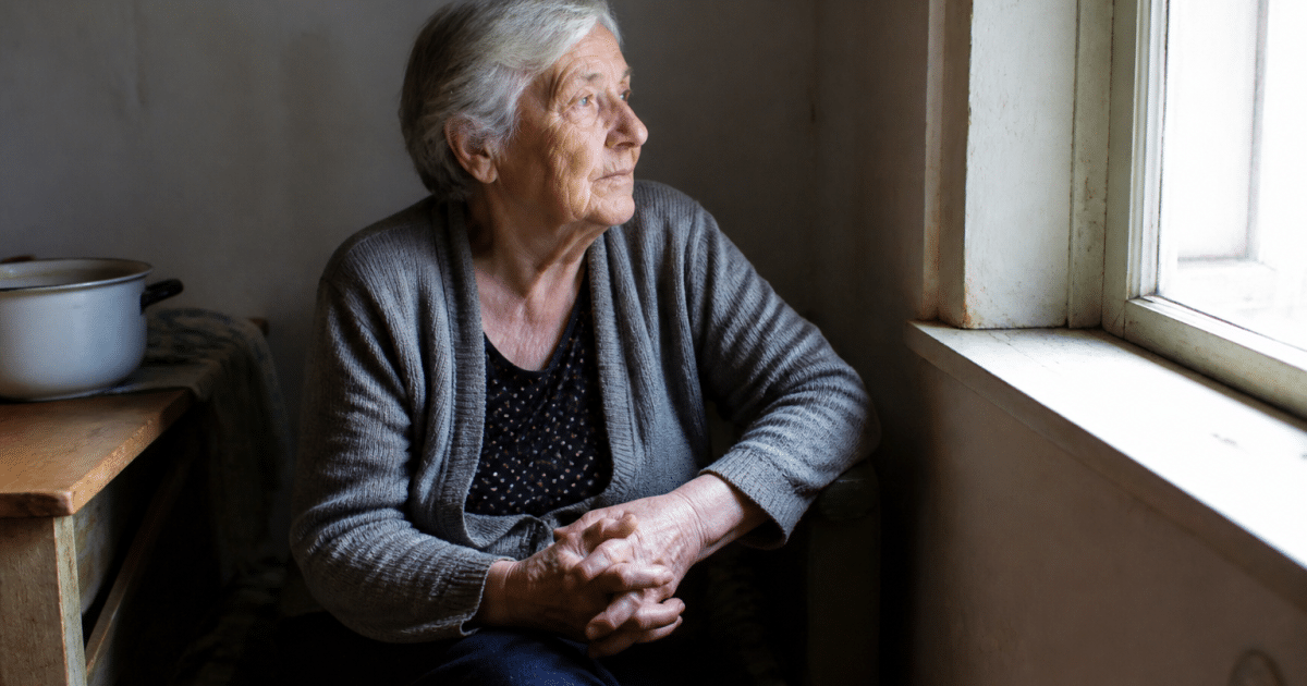 Personne assise, mains jointes, regardant vers la lumière