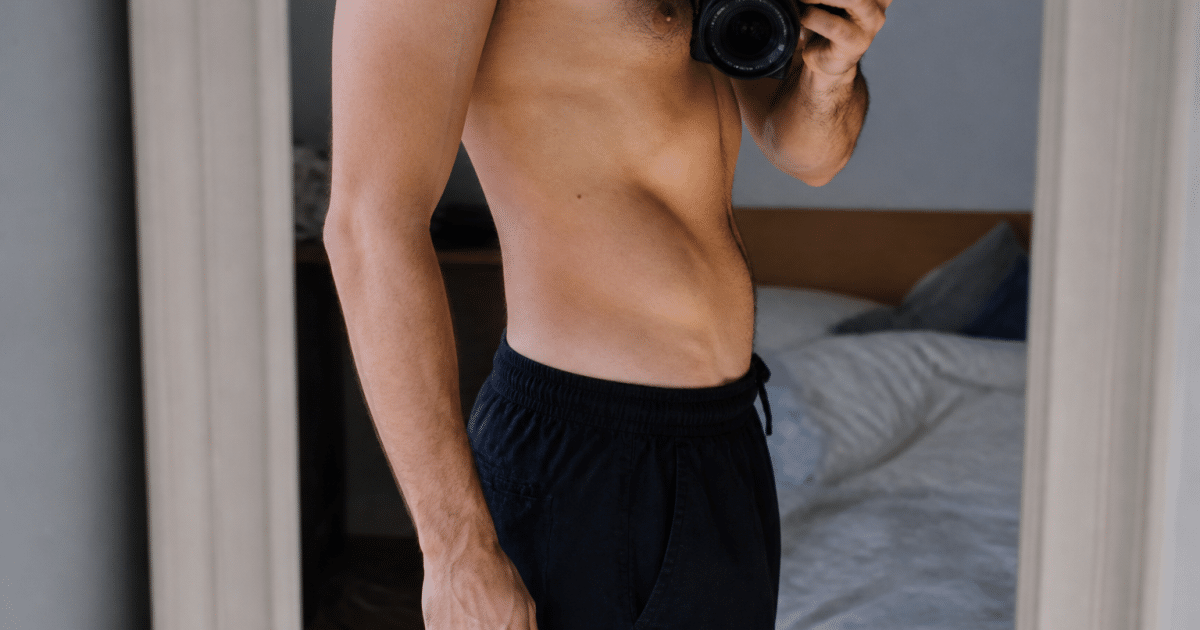 homme debout montrant son ventre plat progressivement reduit