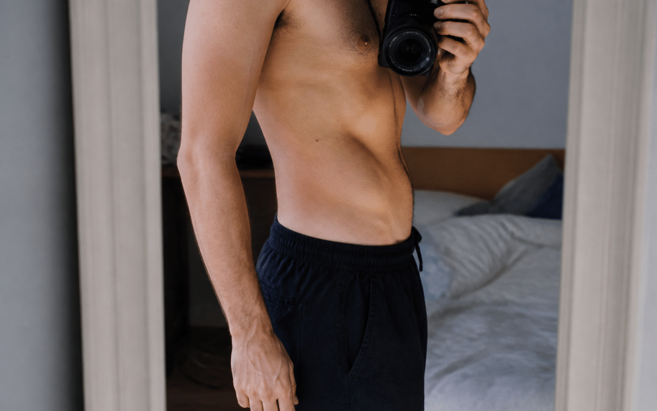 homme debout montrant son ventre plat progressivement reduit