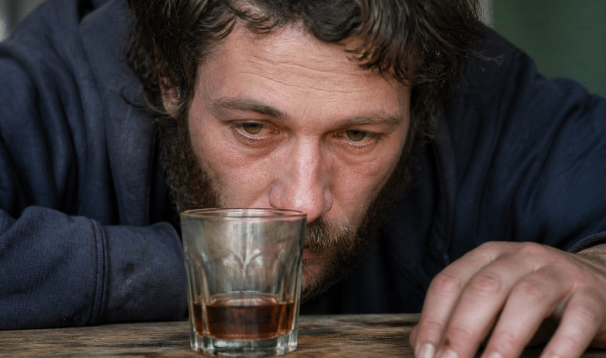 Personne aux yeux jaunes rouges penchee sur verre alcool